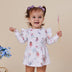 Child wearing a dress with fairy design on a beige background